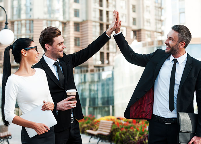 Businessmen and woman giving each other a high five